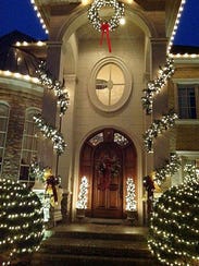 The home’s dramatic front entrance is outlined by lights