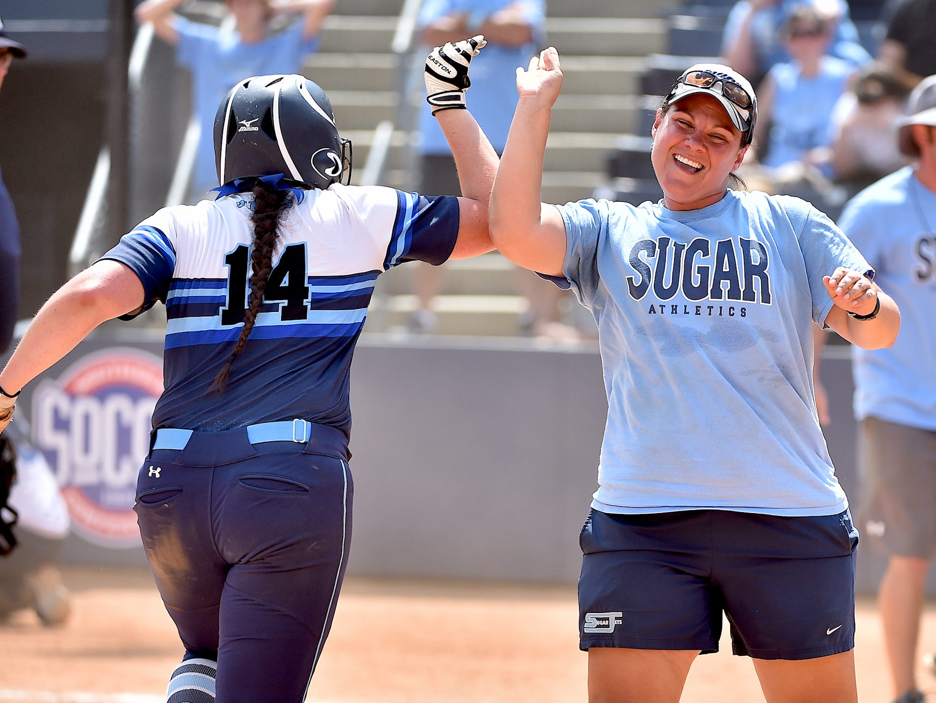Enka softball coach Jennifer Kruk congratulates Addison Harris after her walkoff home run in last month's NCHSAA 3-A championship series played in Greensboro.