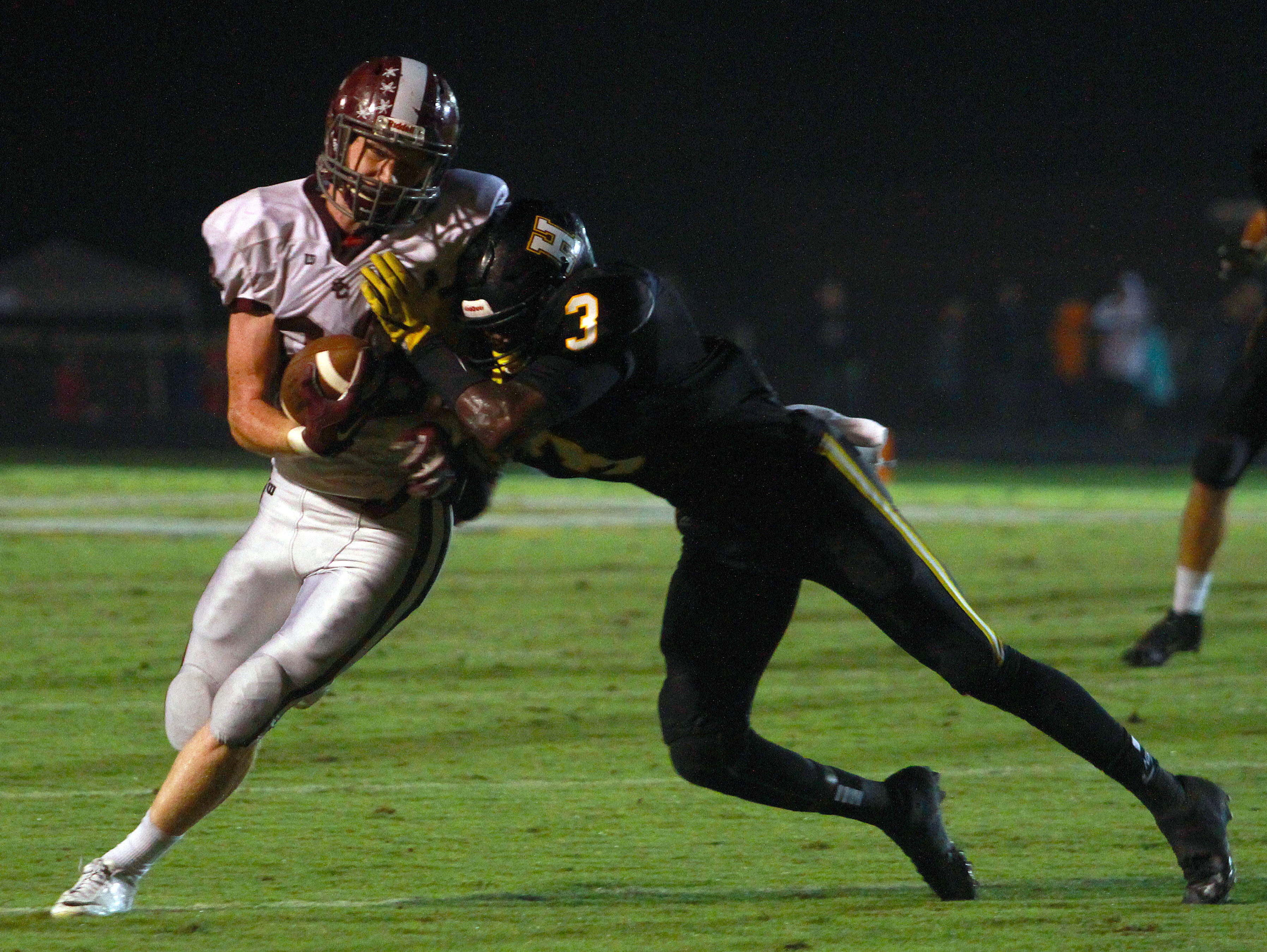 Station Camp's Tyler White makes the reception as Hendersonville's Josh Grieve makes the tackle during Friday's game.