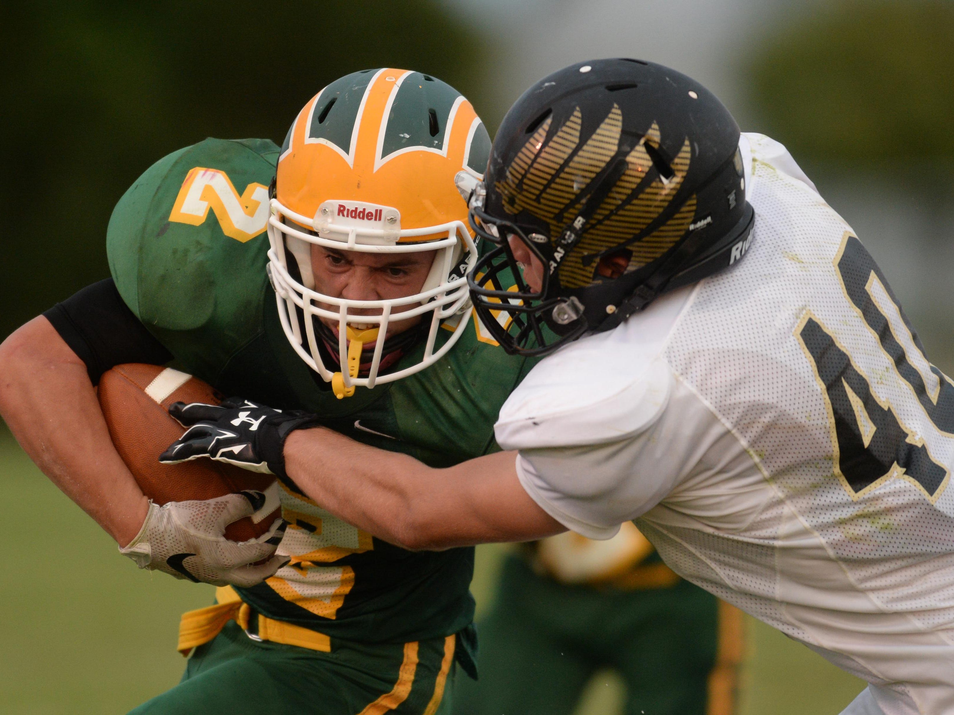 Northeastern's Alec Hughes carries the ball against Winchester's Tyler Edwards during a football game Friday in Fountain City.