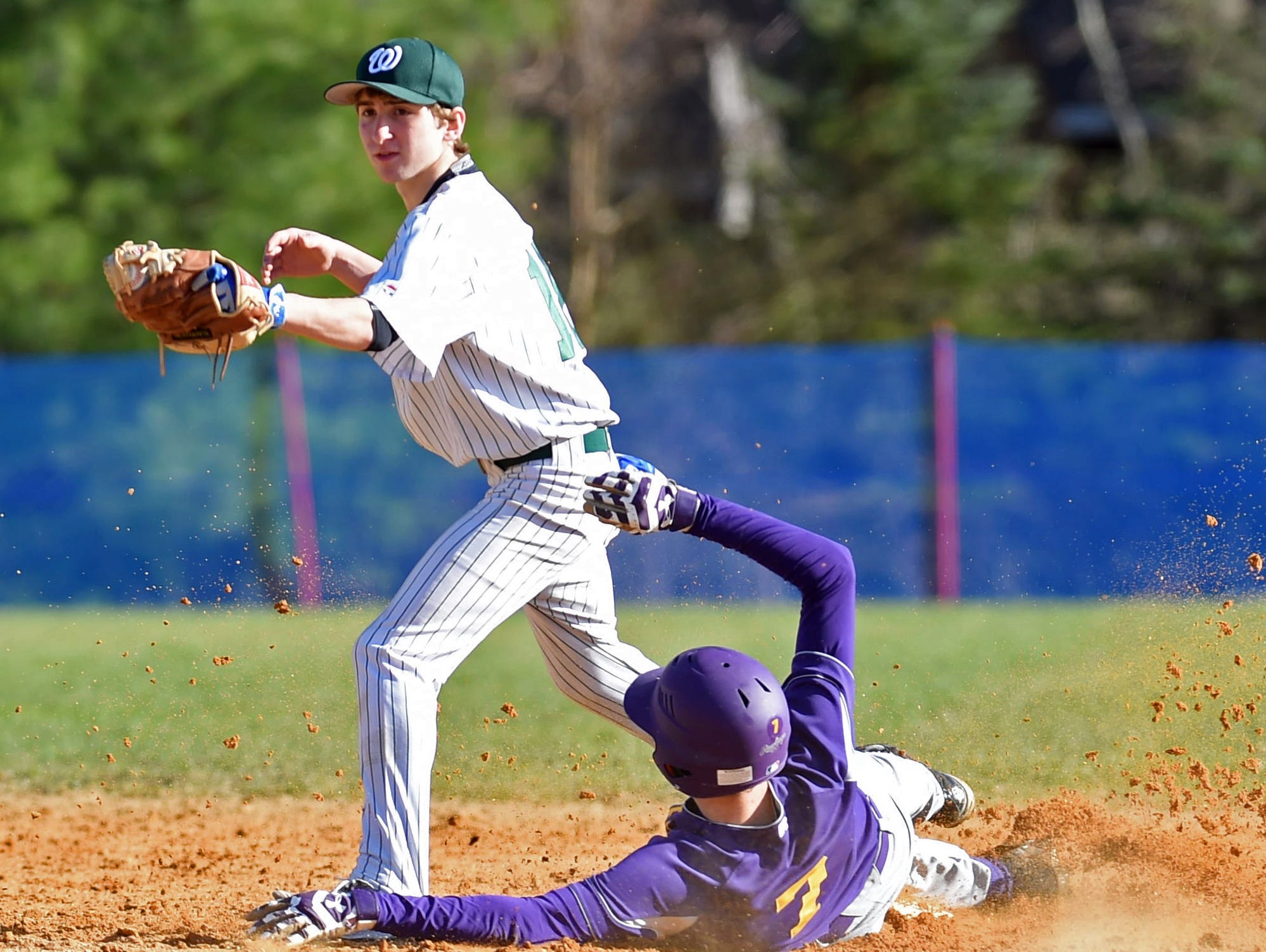 Rhinebeck's Aidan Hack slides into second base under Webutuck's Chris Milano during Wednesday's game at Rhinebeck.