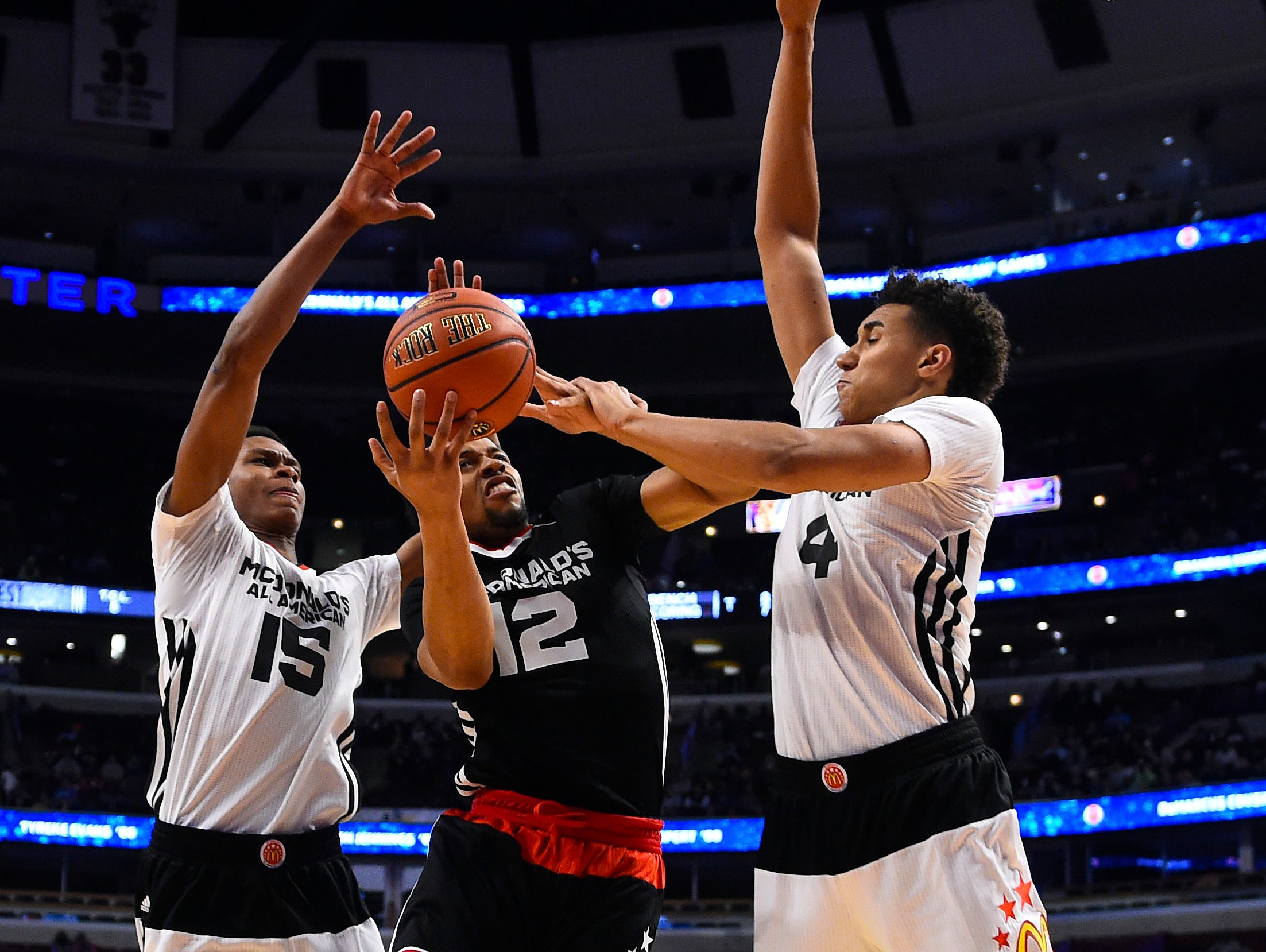 Apr 1, 2015; Chicago, IL, USA; McDonald's All American East guard Isaiah Briscoe (12) shoots the ball against McDonald's All American West guard PJ Dozier (15) and center Chase Jeter (4) during the first half at the United Center. Mandatory Credit: Mike DiNovo-USA TODAY Sports