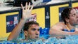 Michael Phelps holds up five fingers during the finals