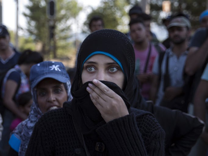 A young Syrian woman waits to cross the border with