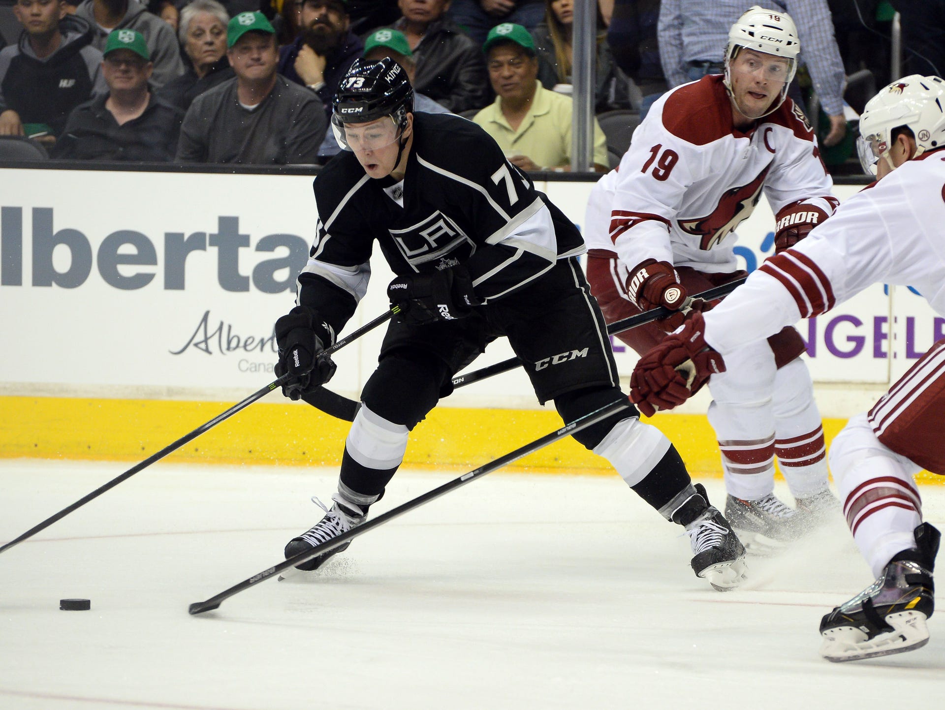 Kings center Tyler Toffoli (73), Coyotes right wing David Moss (18) and defenseman Michael Stone (26) fight for control of the puck during the second period.
