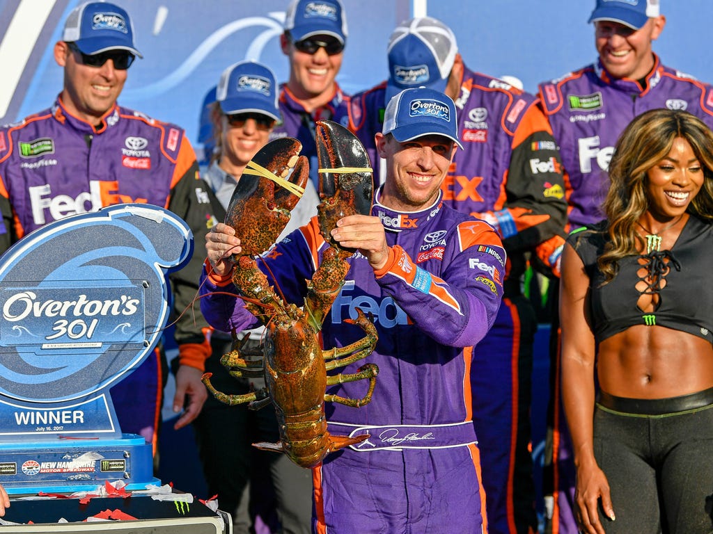 Monster Energy NASCAR Cup Series driver Denny Hamlin holds up a lobster after winning the Overton's 301 at New Hampshire Motor Speedway in Loudon, N.H.