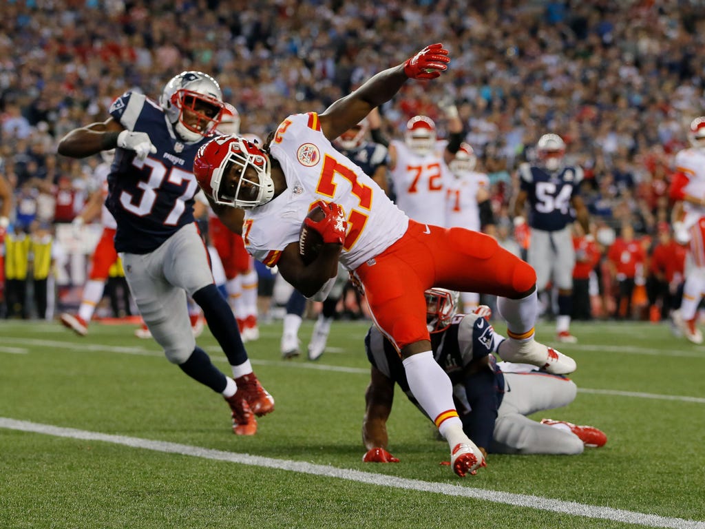 Kansas City Chiefs running back Kareem Hunt runs the ball for a touchdown in front of New England Patriots strong safety Jordan Richards, left, and cornerback Malcolm Butler at Gillette Stadium in Foxborough, Mass.