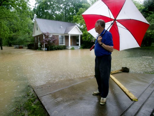 Neighbor Buford Eubanks looks at a flooded house at