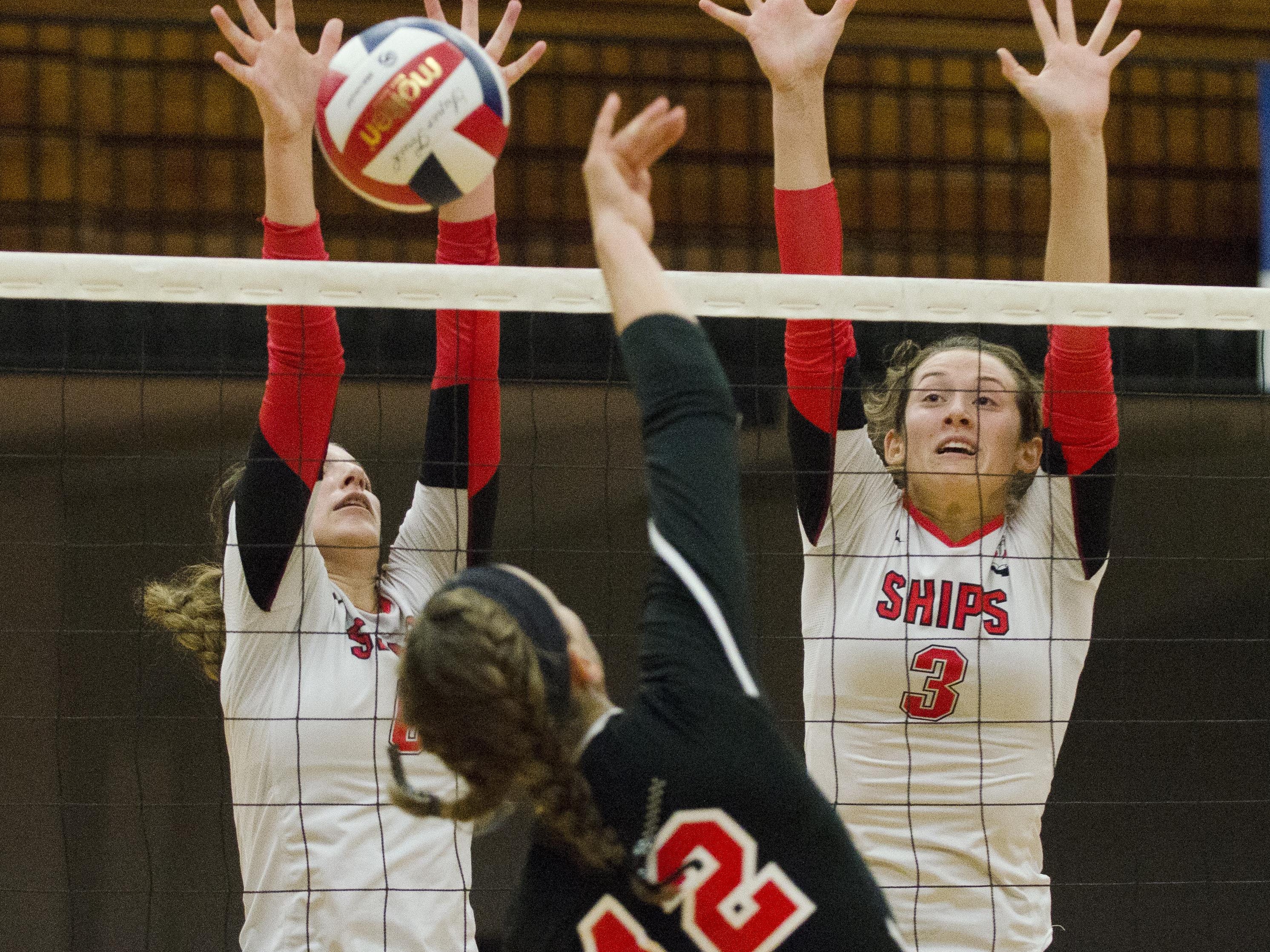 Manitowoc Lincoln's Rayna Figueroa, left, and Christina Maser successfully block a spike from Sheboygan South's Ashley Weimann during the first game of a match against Sheboygan South at the JFK Fieldhouse Thursday.