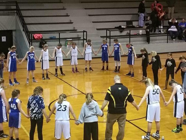 Basketball players in Shelby Eastern Schools recently prayed with coaches after a game.