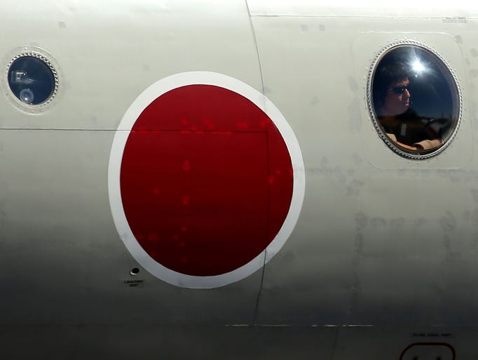 A crew member on a Japanese Maritime Self Defense Force P3 Orion looks from an observation window as the aircraft taxis at an Australian air force base in Pearce.