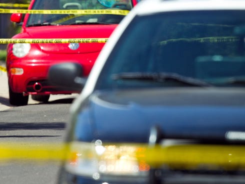 Police officers stand outside a house in Gilbert, Ariz., on Wednesday, May 2, 2012.