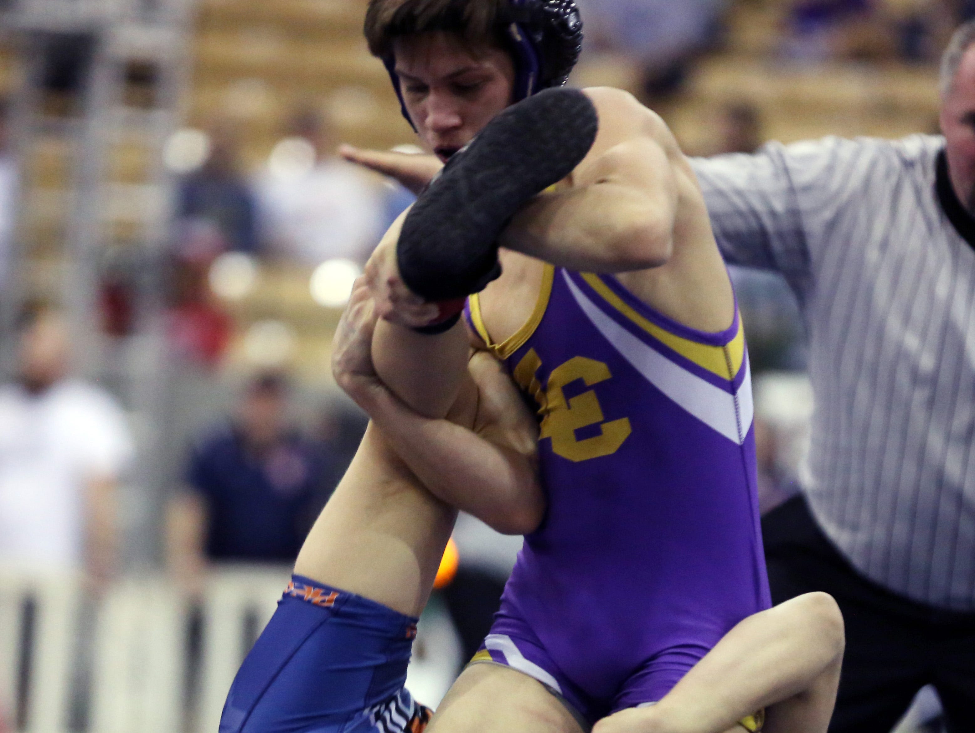 Beech High School's Brayden Palmer, back, in blue and orange, competes with Luke Dezember of Lawrence, standing in purple, white and yellow, during the 106-pound semifinals at the TSSAA State Wrestling Tournament Friday.