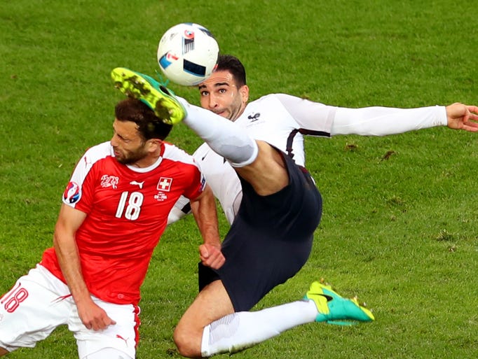 France's Adil Rami kicks the head of Switzerland's