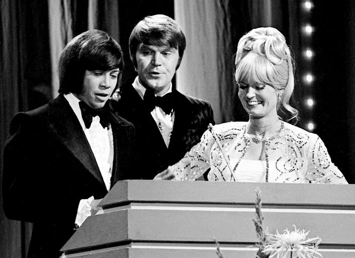 Host Glen Campbell, center, checks on presenters Bobby Goldsboro and Lynn Anderson as they set up to present the Vocal Duo of the Year during the sixth annual CMA Awards show Oct. 16, 1972.