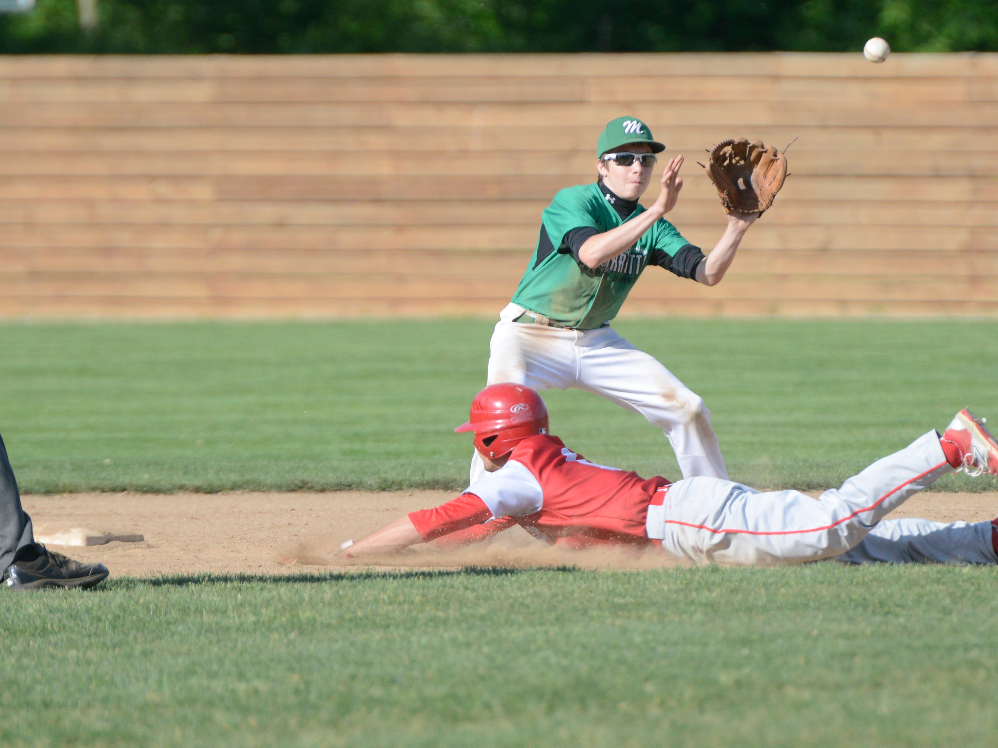 Huron's Kyle Kovach slides past Margaretta's Noah Esposito and is safe Thursday afternoon in a Division III district semifinal. Huron won 8-5.