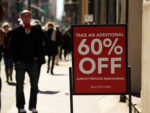 A clothing sale sign stands outside of a store in Manhattan