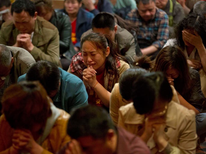 Relatives of Chinese passengers on the missing Malaysia Airlines flight weep in a prayer room in Beijing.