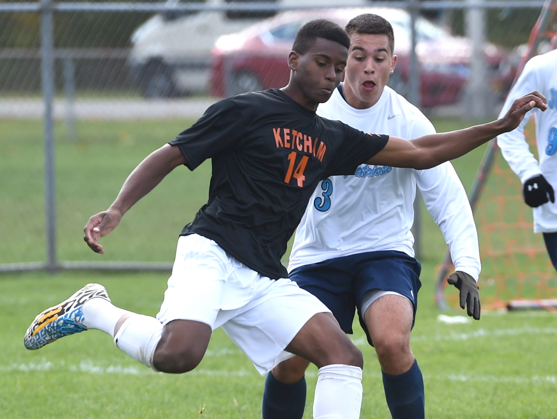 Ketcham's David Siriboe passes the ball past John Jay's Luke Melvin during Saturday's game in Wappingers Falls.