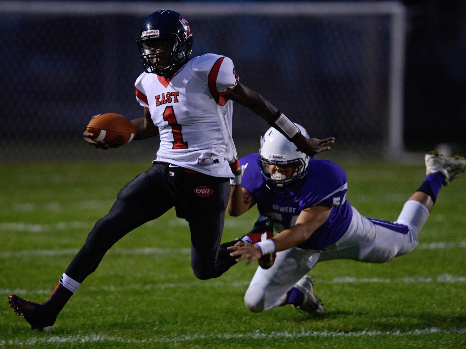 Green Bay East’s Deonte Carlton tries to shake a tackle by Green Bay West’s Tyler Chanthavong in a Bay Conference game last Friday. Carlton is second in the Bay with 498 rushing yards this season.