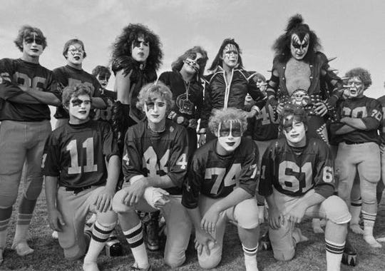 The band Kiss poses with members of the Cadillac High