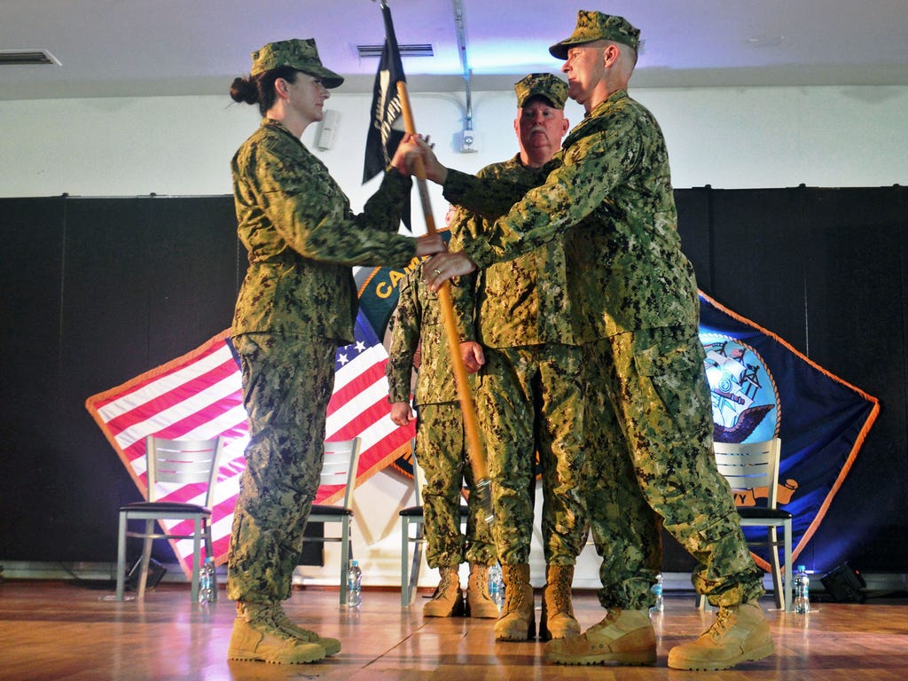 Captain Nancy S. Lacore, left, receives a flag from outgoing Captain James H. Black during a handover ceremony at the Camp Lemonier U.S. Navy base in Djibouti on July 20, 2017. \u000aCaptain Lacore is the first woman captain to be in charge of the ov