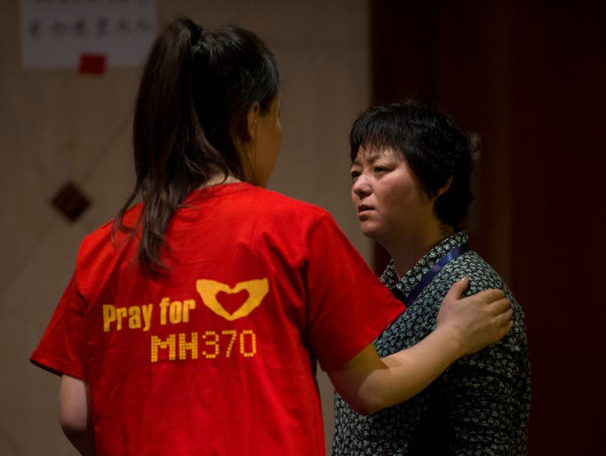 A woman who has a relative on the missing Malaysia Airlines flight comforts another woman before a briefing by Malaysian officials at a hotel in Beijing.