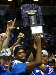 Duke players hold up the ACC tourney title trophy.