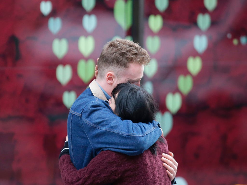 A couple hug at the north end of London Bridge in London after leaving flowers at a memorial for the victims of the terror attack.