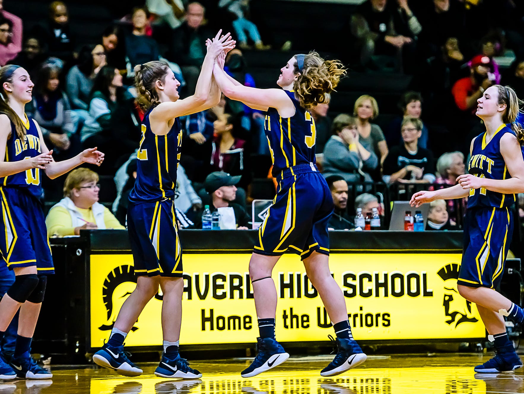 Grace George ,second from right, high-fuves teammate Piper Phillpis ,second from left, after their win over Waverly Friday February 10, 2017 in Delta Township. KEVIN W. FOWLER PHOTO