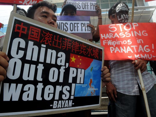 Protesters brandish placards at a rally in front of