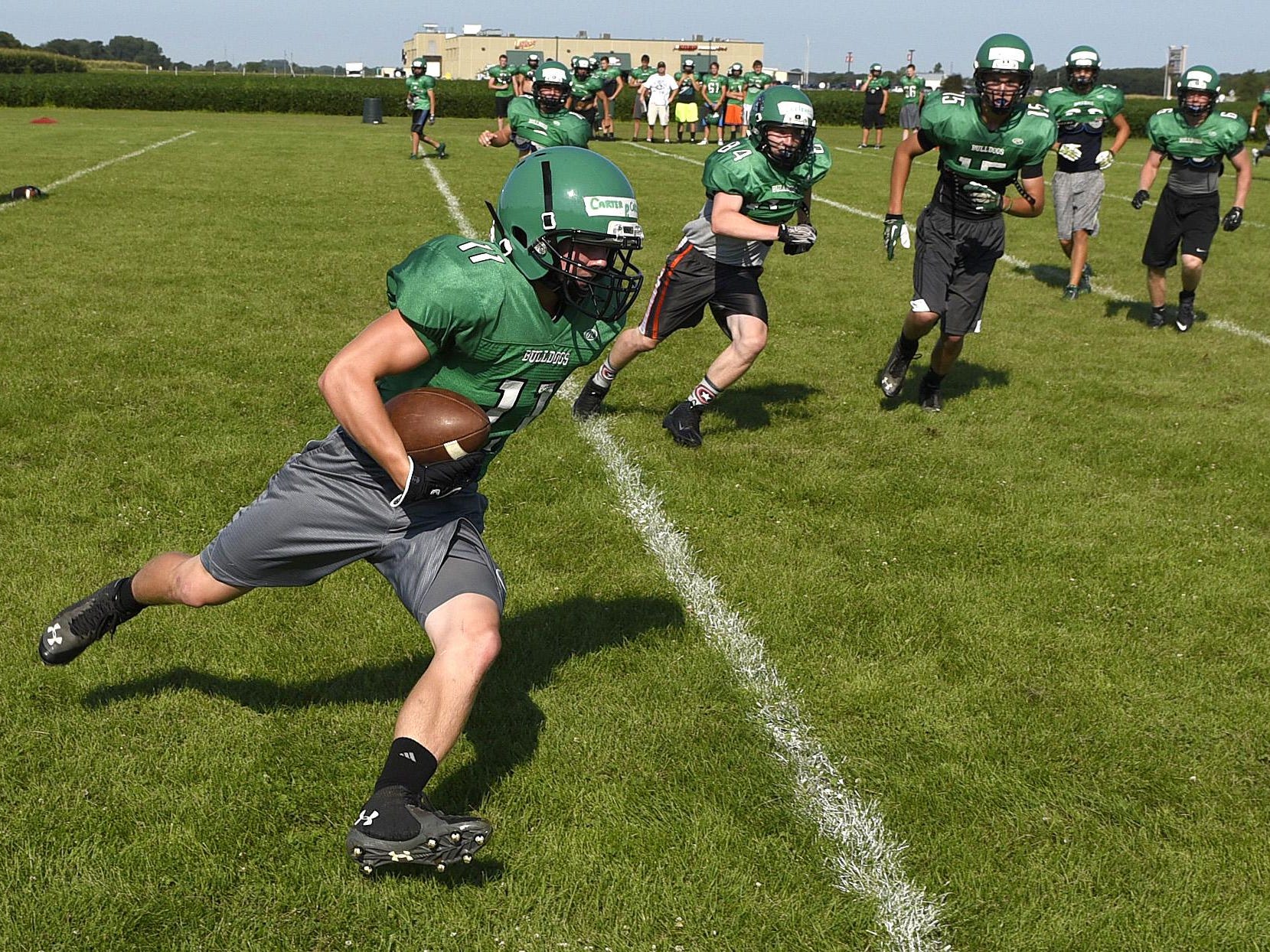 Paynesville’s Carter Carlson turn the outside corner of the line on a run play.