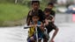 Filipino children ride bicycles through floodwaters in the city of Taguig.