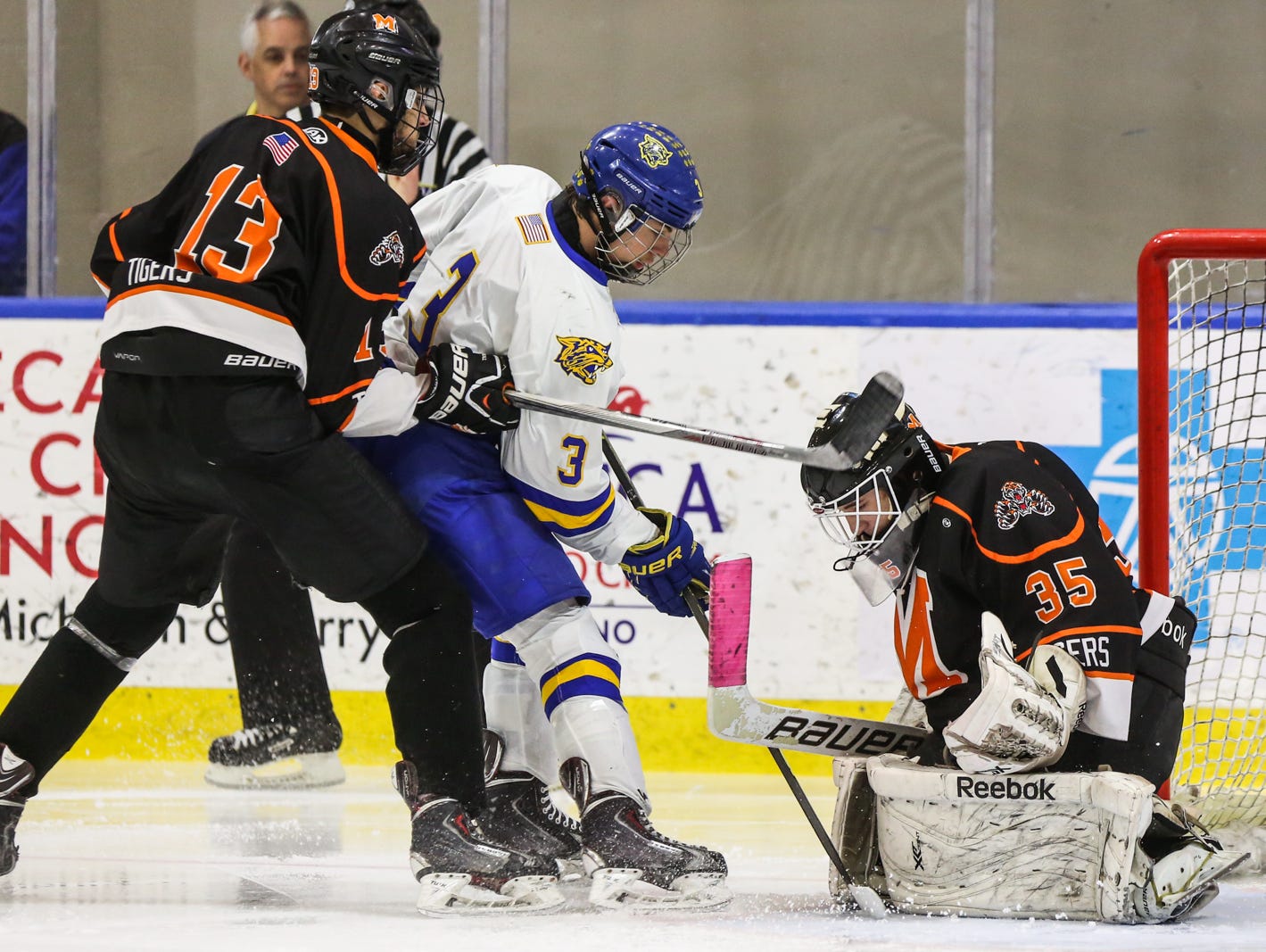 Mamaroneck goalie Tommy Spero makes a save agaisnt West Genesee's Jay Considine as Kesin Ryan Dehejia checks him in the second period of Sunday's Division 1 state championship game in Buffalo. Mamaroneck defeated West Genesee 1-0.