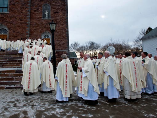 Priests line up to see Bishop Christopher Coyne installed