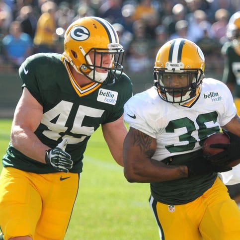 Green Bay Packers running back LaDarius Perkins grabs a pass in front of linebacker Jake Doughty during training camp practice Wednesday at Ray Nitschke Field.