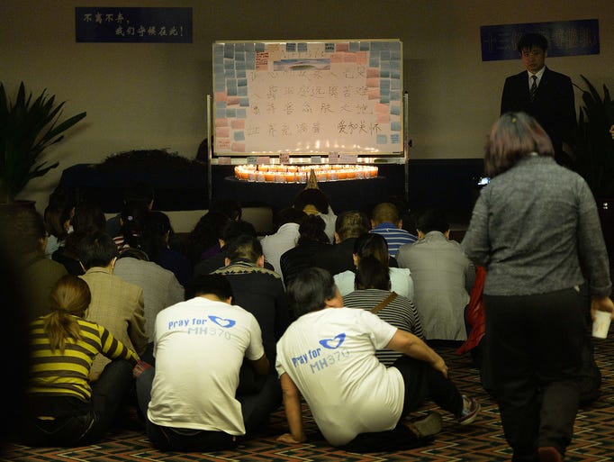 Chinese relatives of passengers on the missing Malaysia Airlines fligh pray in a room at the Metro Park Lido Hotel in Beijing. The airliner with 239 people on board disappeared on a flight from Kuala Lumpur to Beijing on March 8.