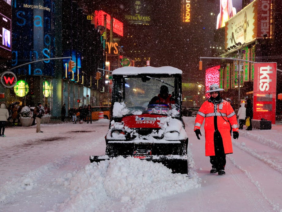 A small plow is driven through Times Square on January