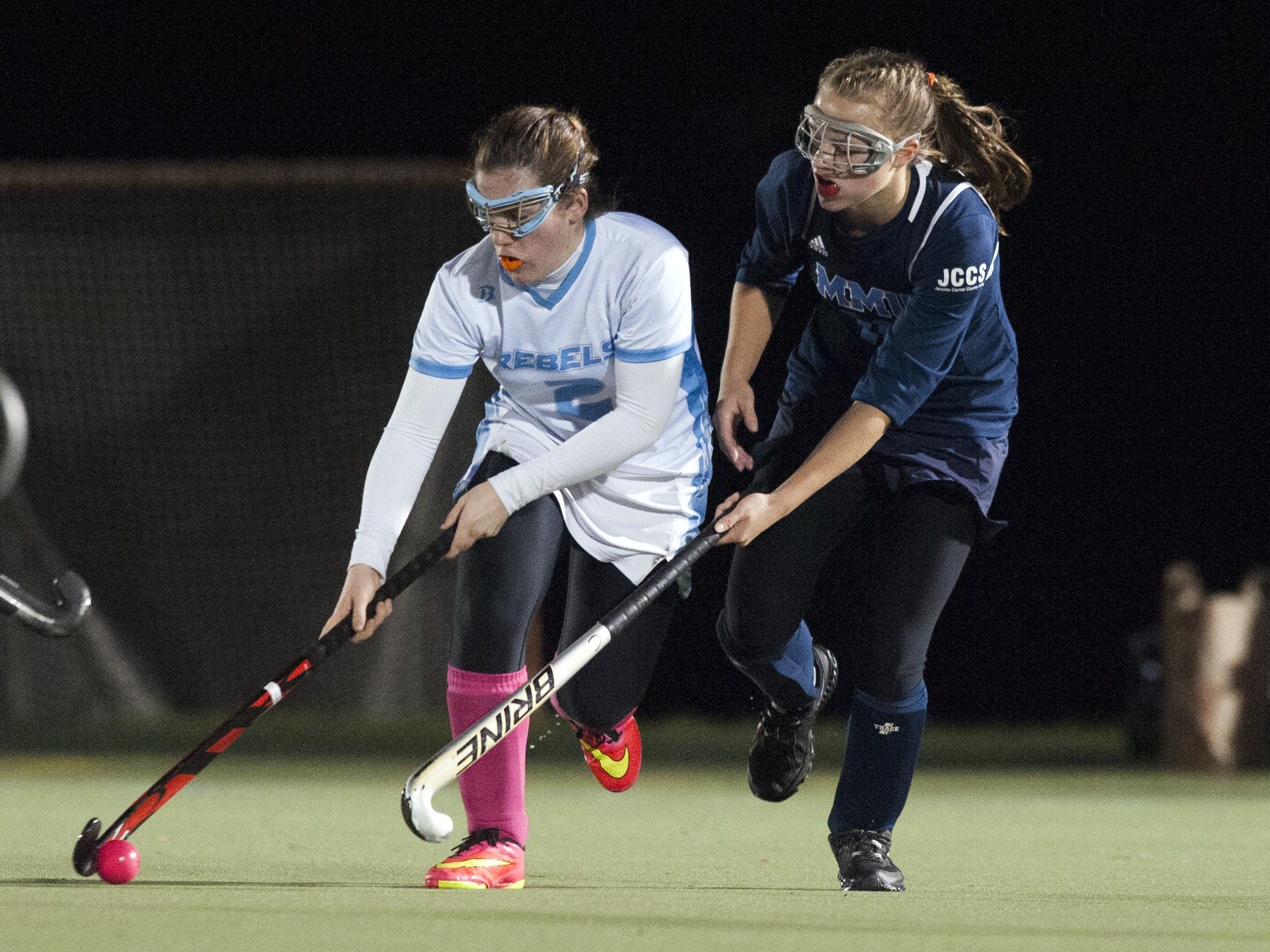 South Burlington’s Kate Hall (2) runs past MMU’s Ginny Churchill (11) during a Division I high school field hockey semifinal game at Middlebury College.