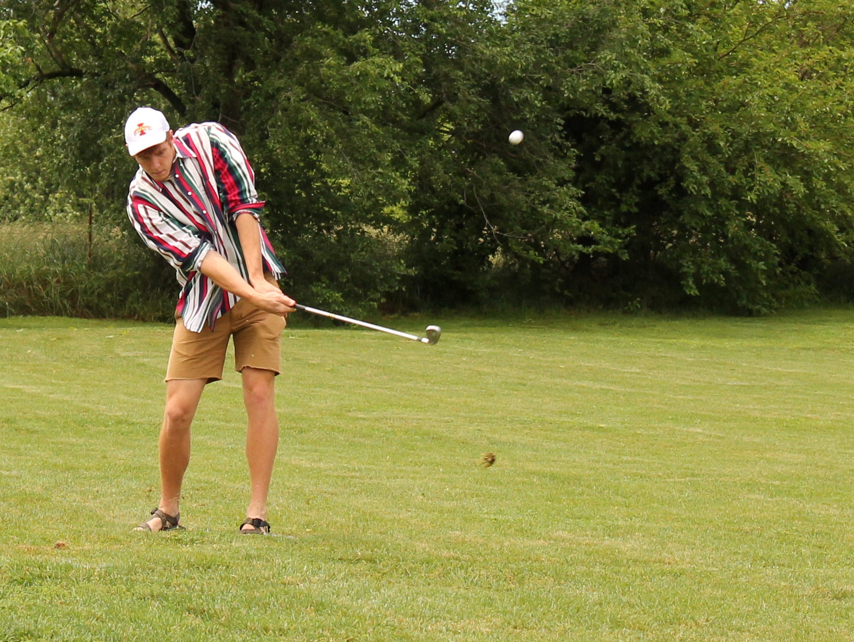 Nixa's Chase Allen hits a tee shot on the second hole of a nine-hole golf course he created in his backyard in order to host the Allen Open golf tournament.