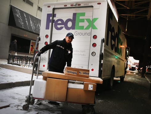 A FedEx Ground worker delivers packages on Dec. 26, in Chicago.