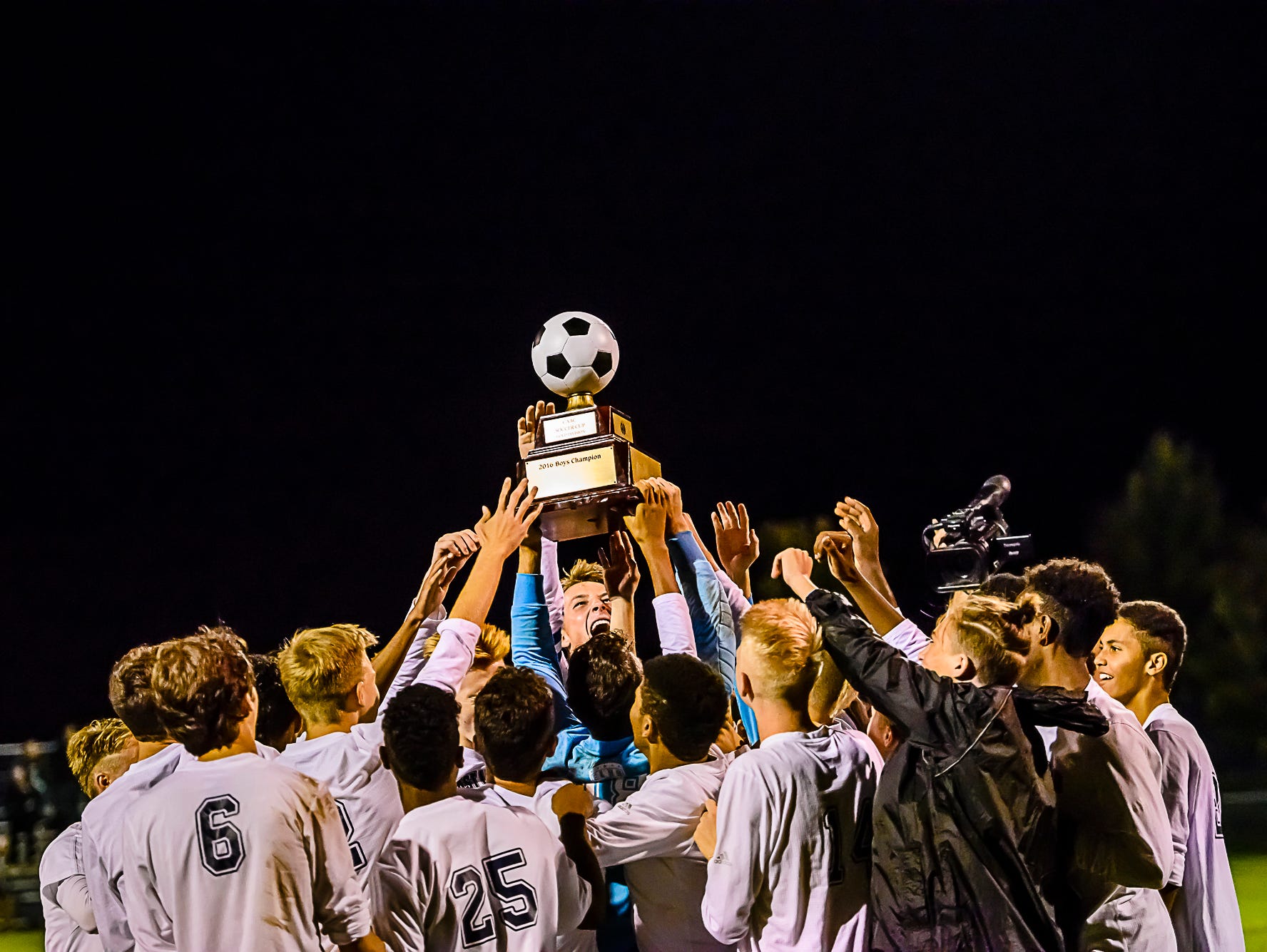 Members of the East Lansing soccer team celebrate their Gold Cup Final win over Haslett Tuesday October 11, 2016 in Mason. KEVIN W. FOWLER PHOTO