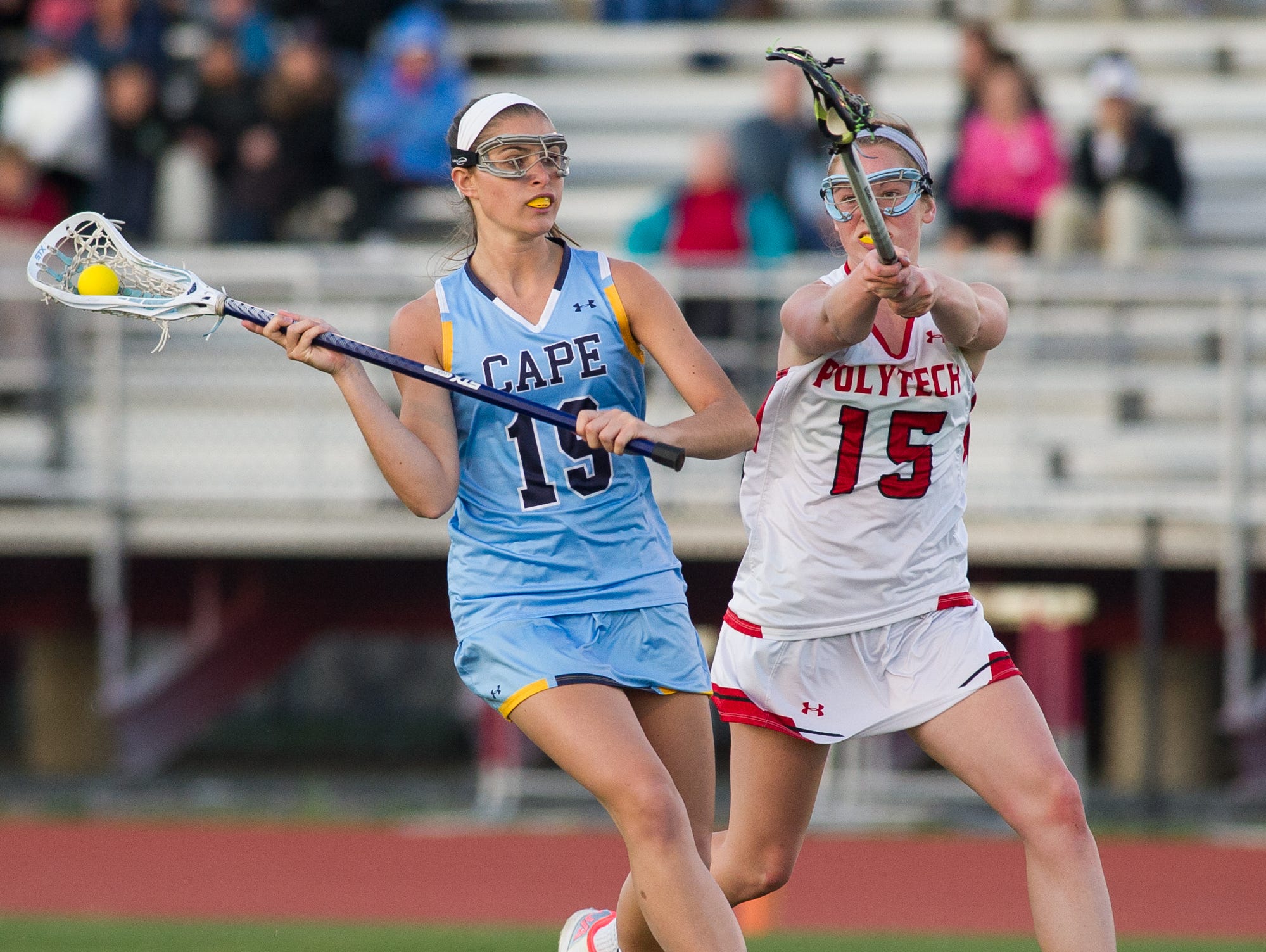 Polytech's Grace Stang (right), tries to stop a shot from Cape Henlopen's Alison Palmer last Wednesday. Cape edged No. 2 Polytech 12-10 to remain No. 1 in girls lacrosse.