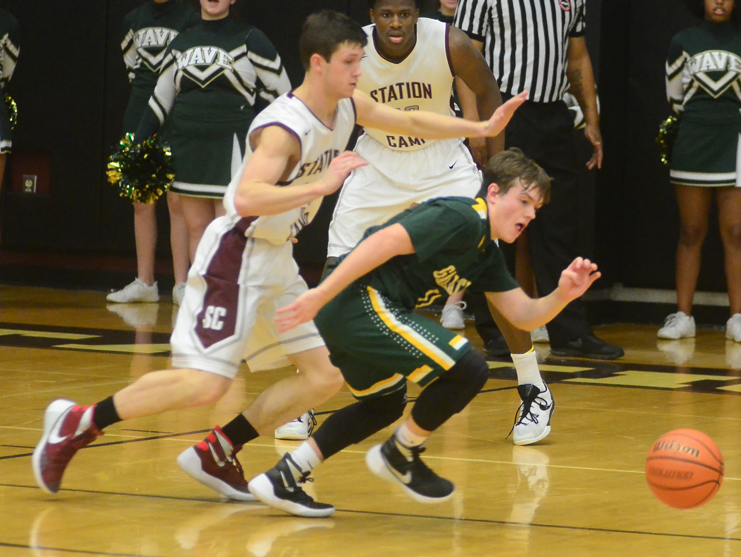 Gallatin High sophomore guard Collin Minor scrambles for a loose ball as Station Camp senior Sawyer Taylor pursues during fourth-quarter action. Minor scored a team-high 15 points.