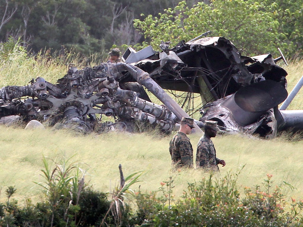US military personnel inspect the site where a CH-53E Super Stallion helicopter burst into flames on Oct. 11 in  Okinawa, Japan on Oct 12, 2017. In the late afternoon of Oct. 11, a US Marines CH-53E chopper made a forced landing in a field due to an 