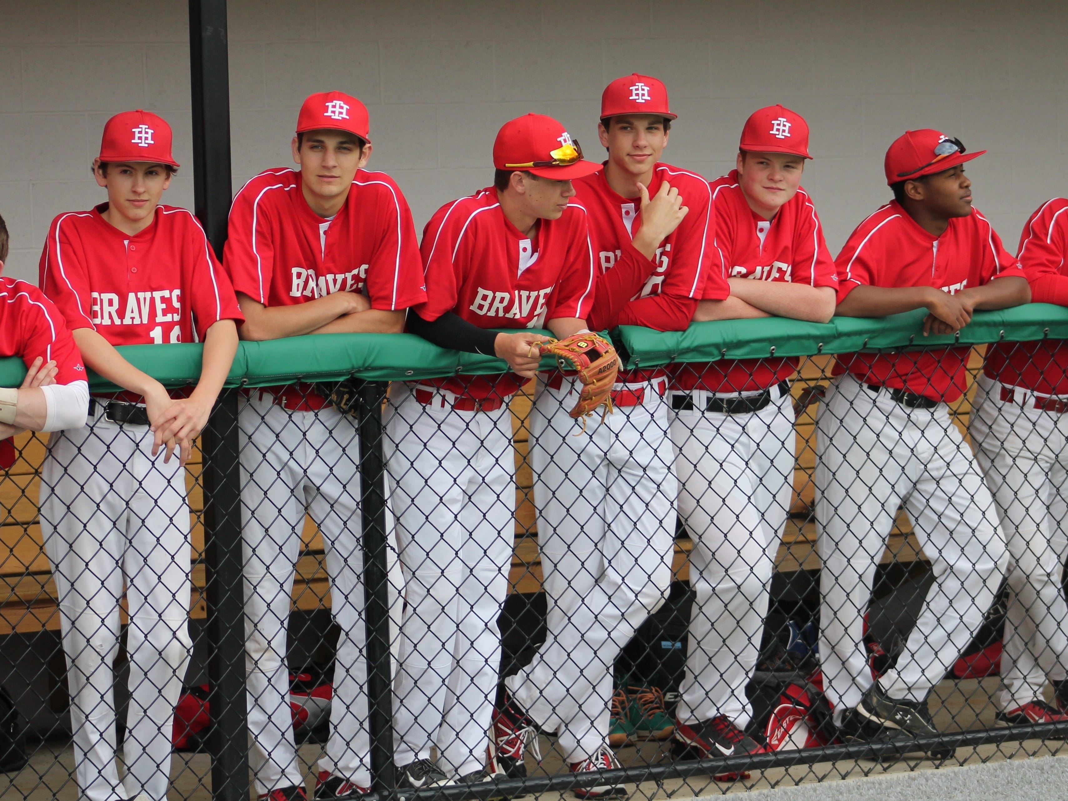 Indian Hill players line the dugout to take in the dedication ceremony of the school’s new baseball/softball complex April 20.