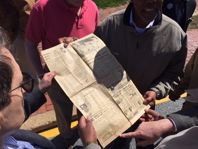 Former P.S. du Pont High student-athletes look at a 1968 Morning News with a Ku Klux Klan ad in the lower left corner. On the other side was a picture page from their state basketball title.