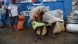 Women protect themselves from the rain with plastic