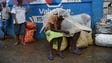 Women protect themselves from the rain with plastic