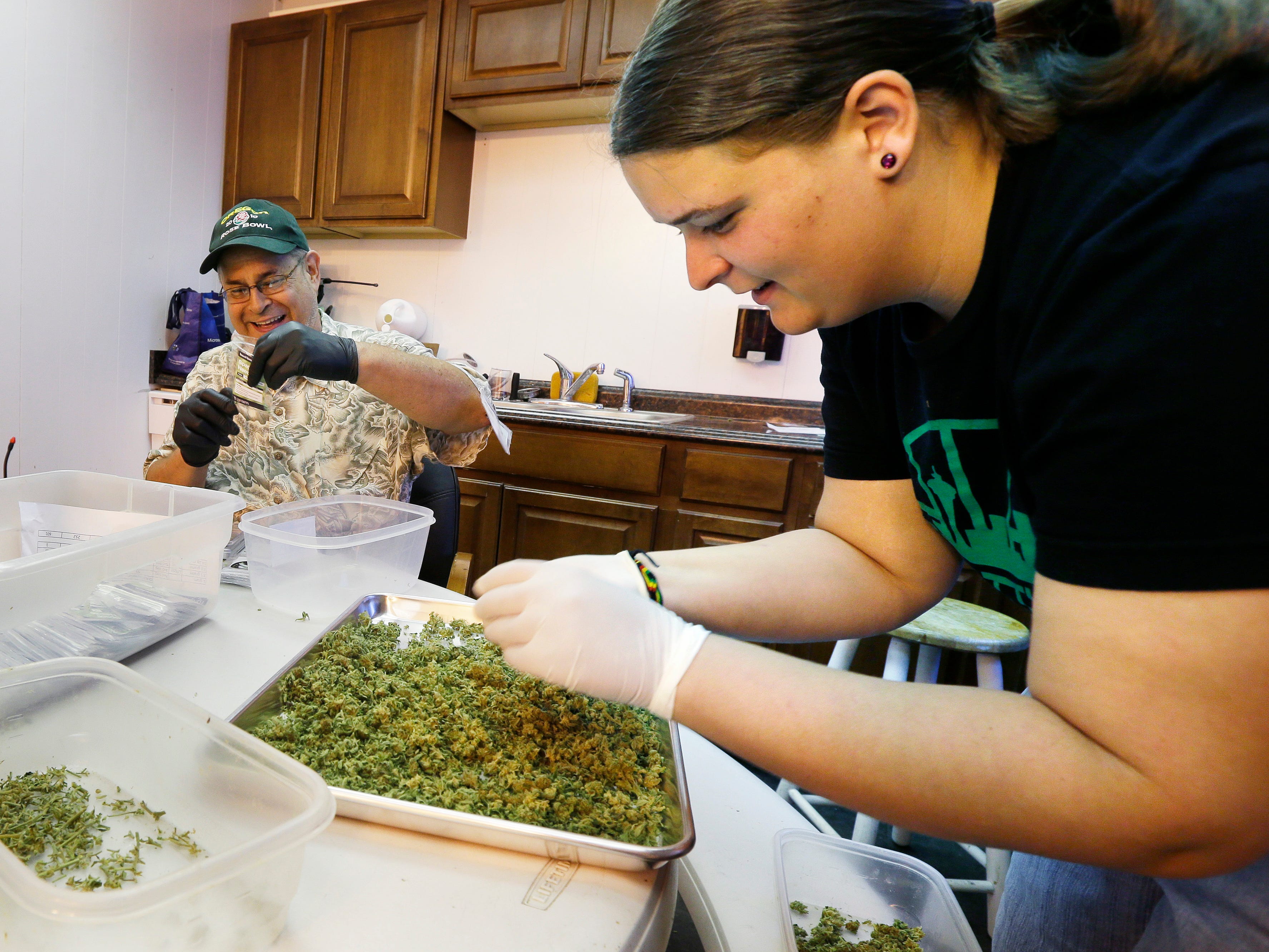 Kristi Tobias prepares packets of a variety of recreational marijuana named 